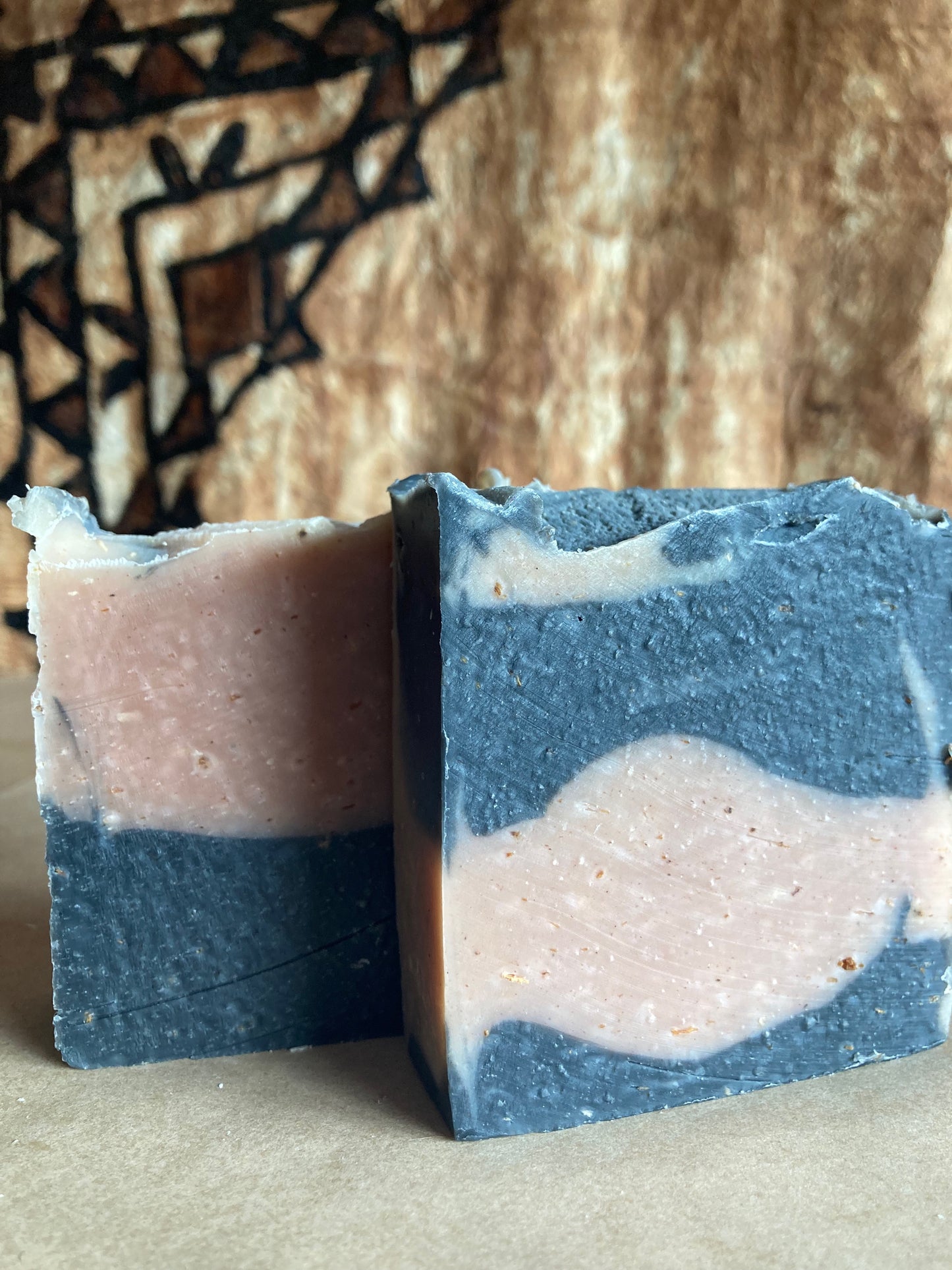 Two bars of soap with a marbled pattern on a textured surface.