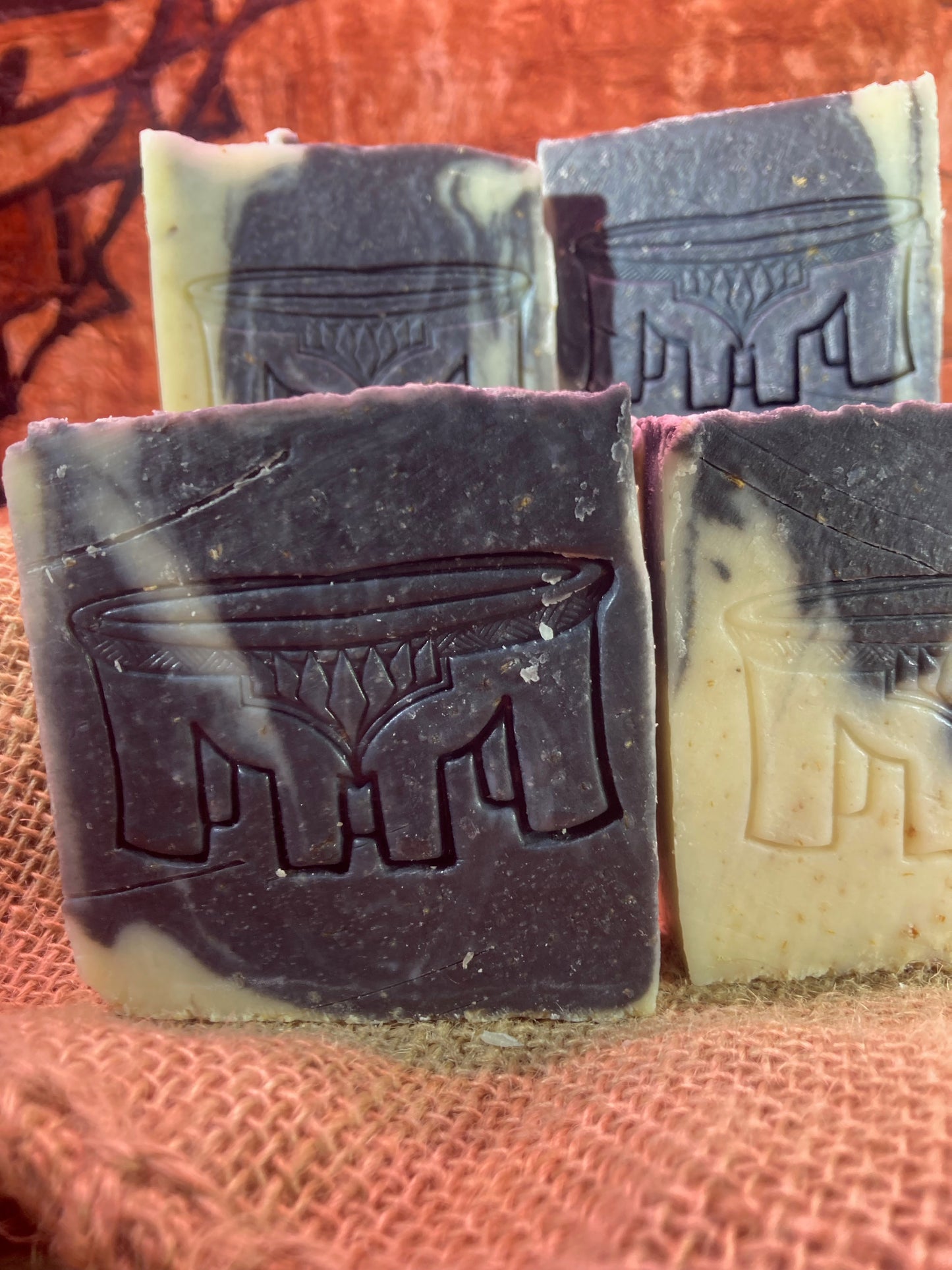 Bar soaps with embossed designs on a textured surface