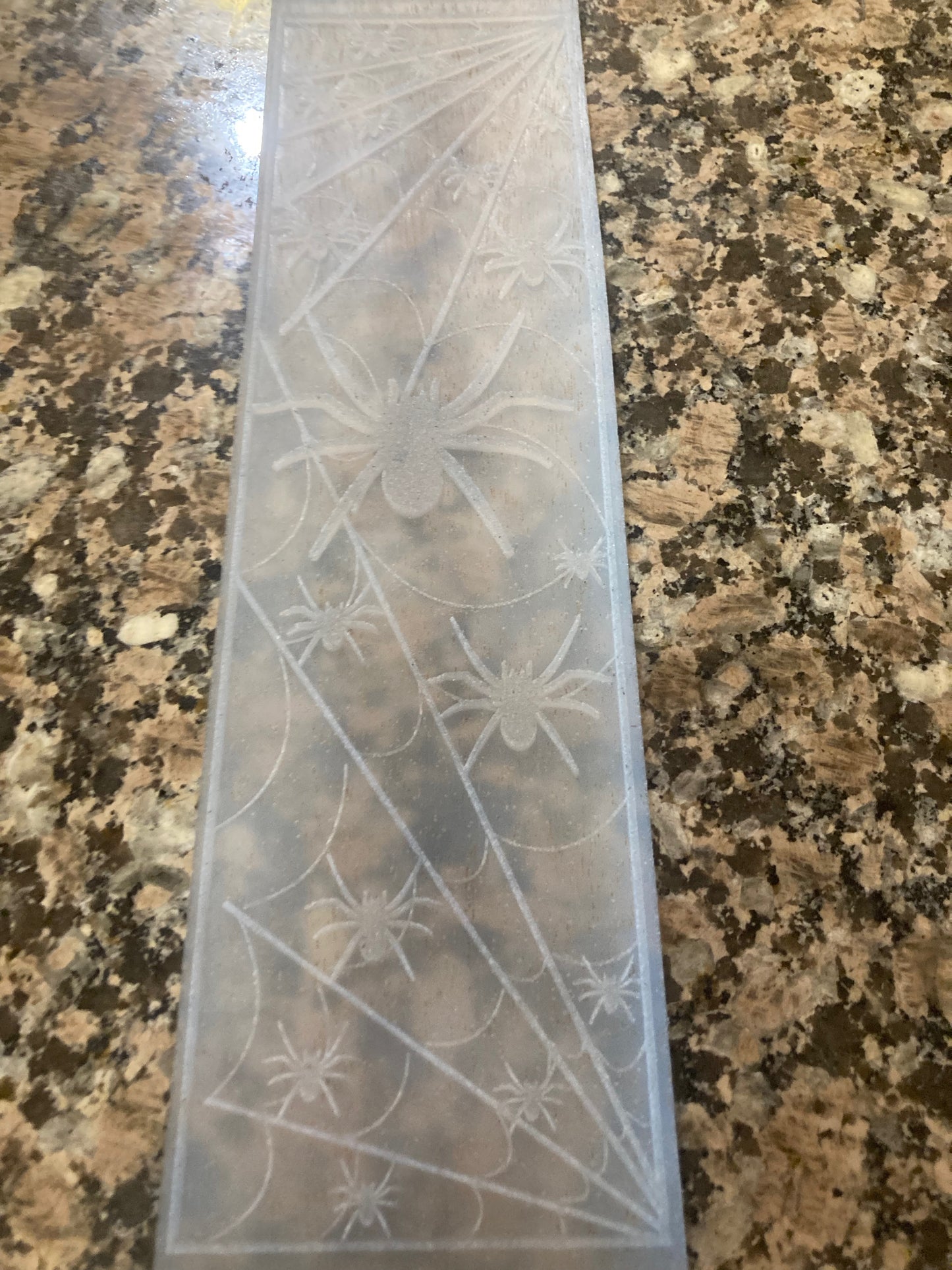 Transparent silicone impression mat with spider web design on a granite countertop