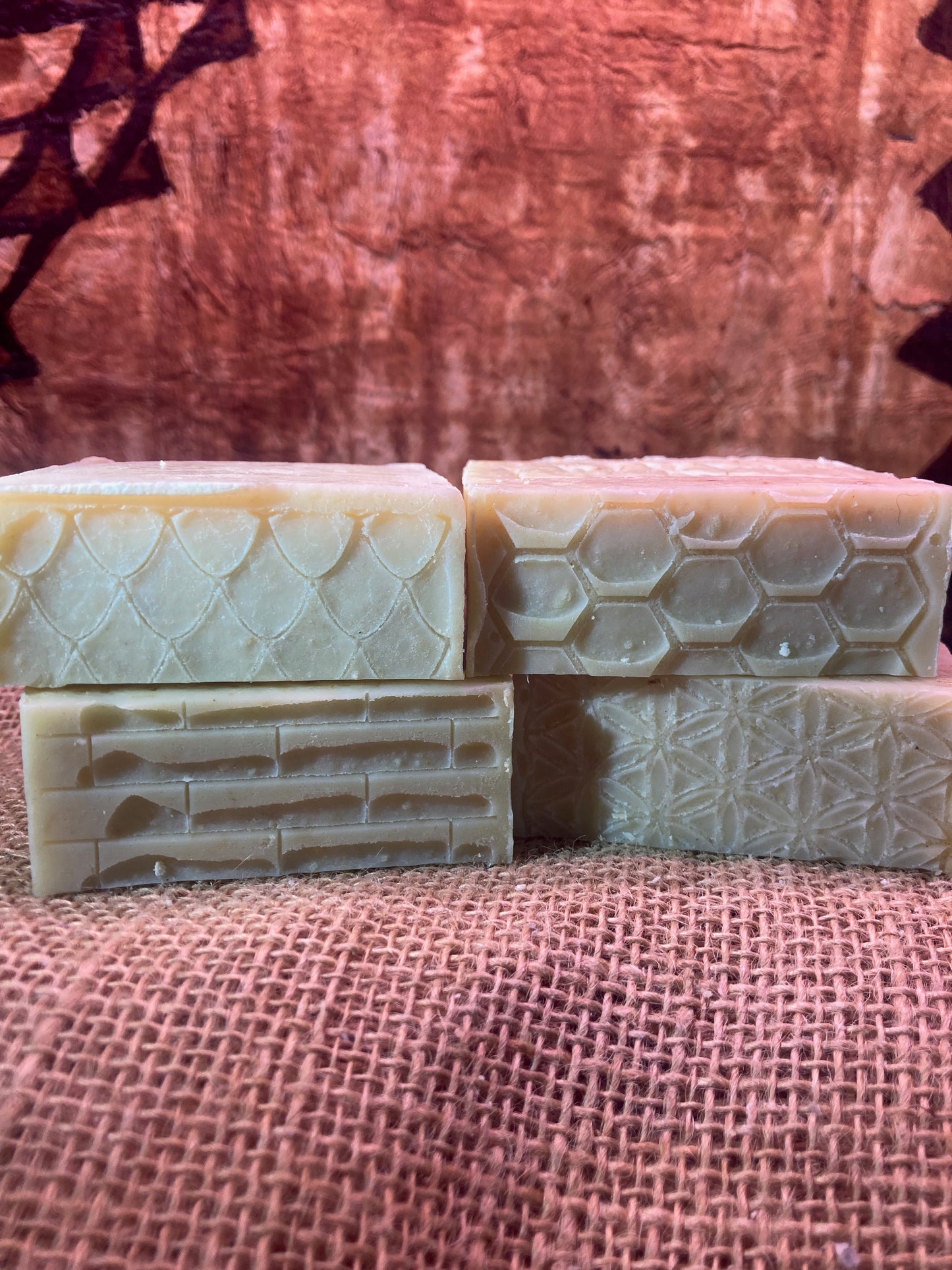 Four bars of soap with textured surfaces on a Burlap Bag