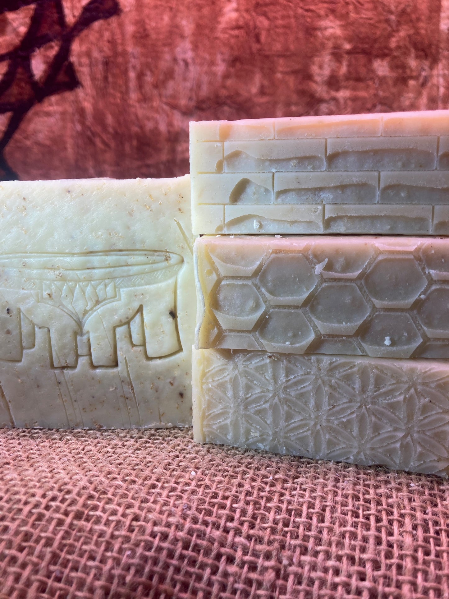 Four bars of soap with textured surfaces on a Burlap Bag