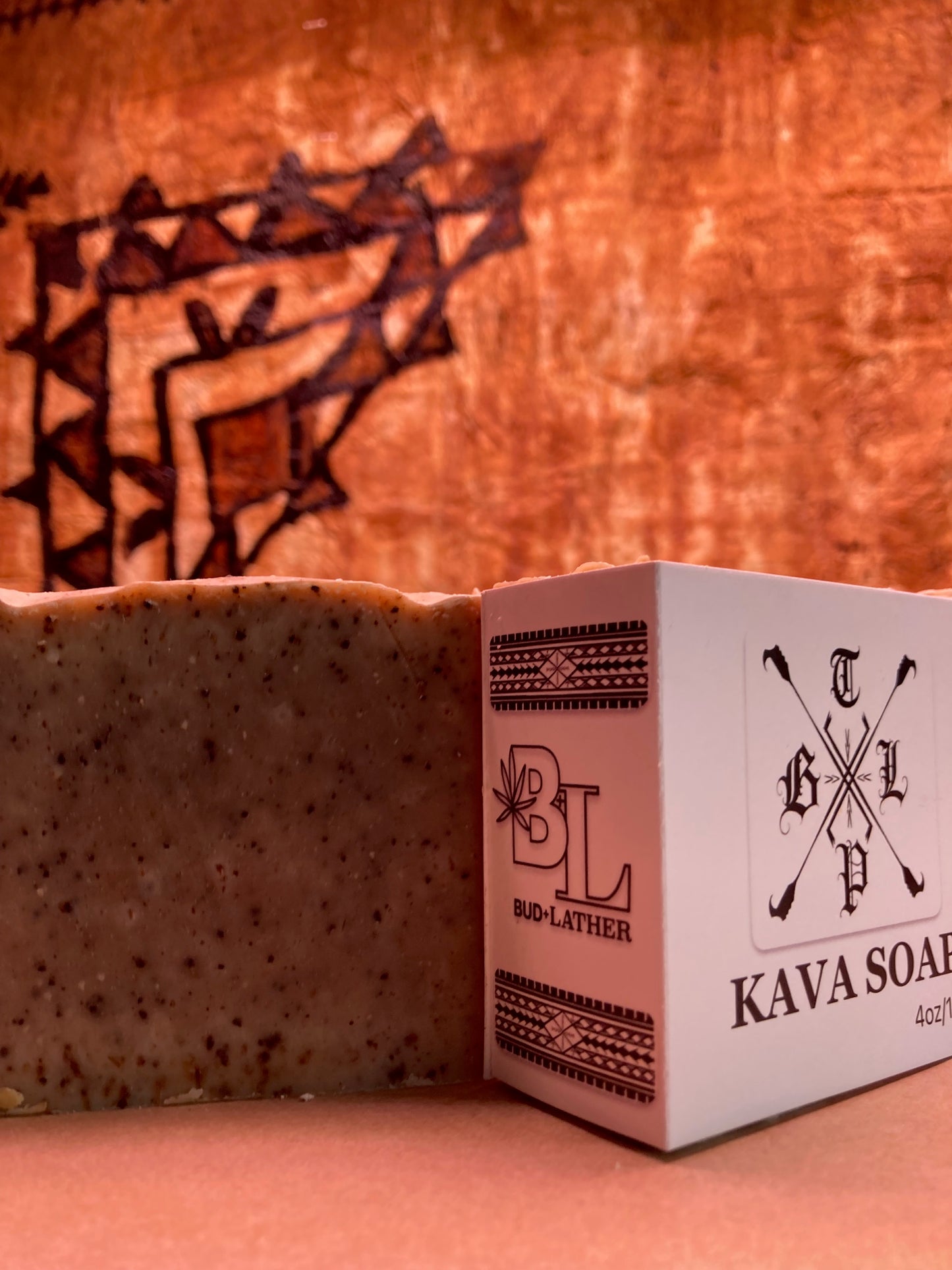 Bar of Kava soap next to its packaging on a wooden background