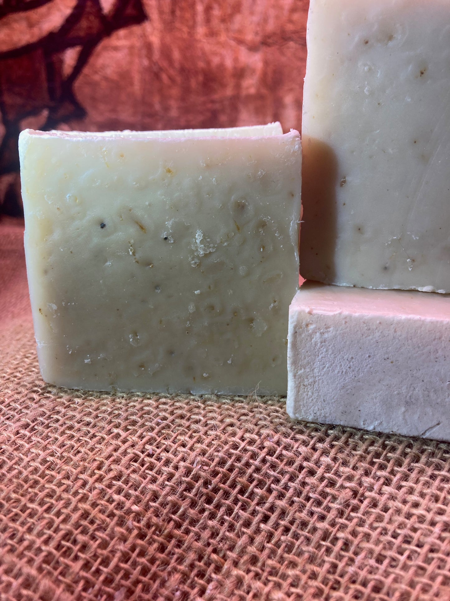 Three bars of soap on a textured brown surface