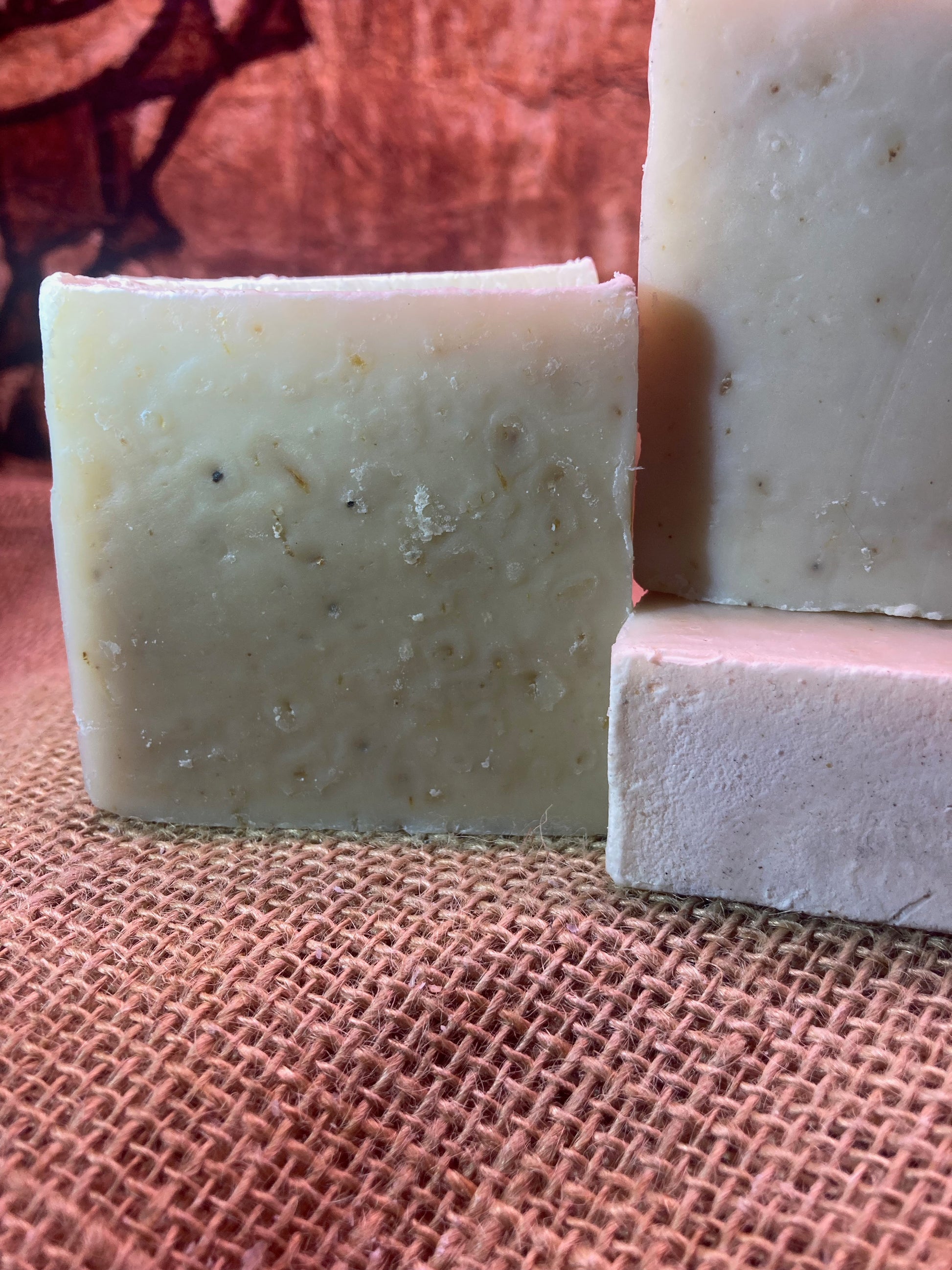 Three bars of soap on a textured brown surface