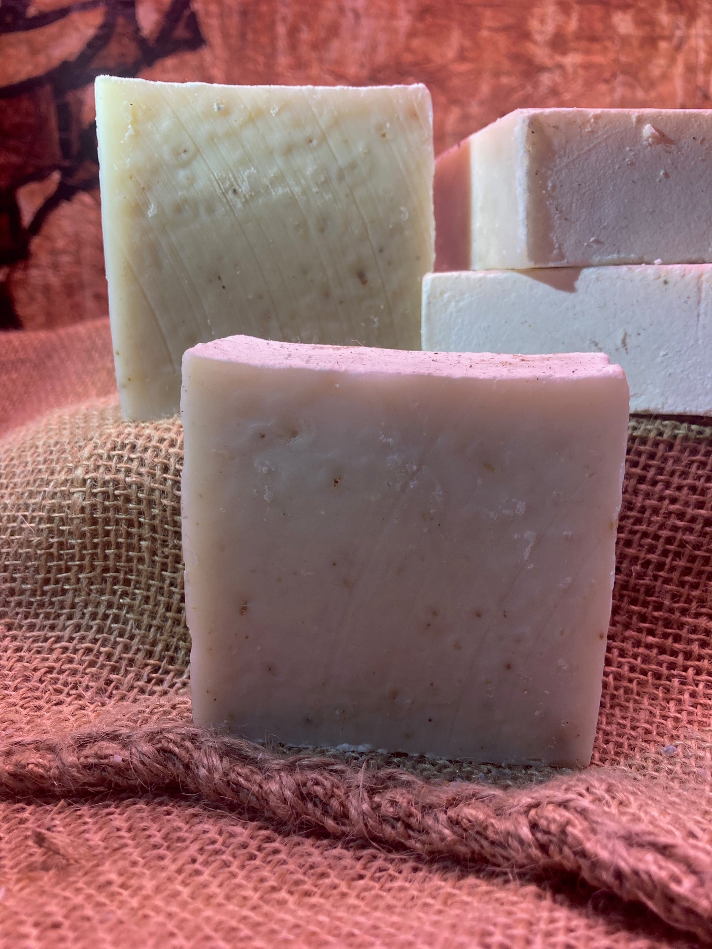 Four bars of soap on a textured fabric background