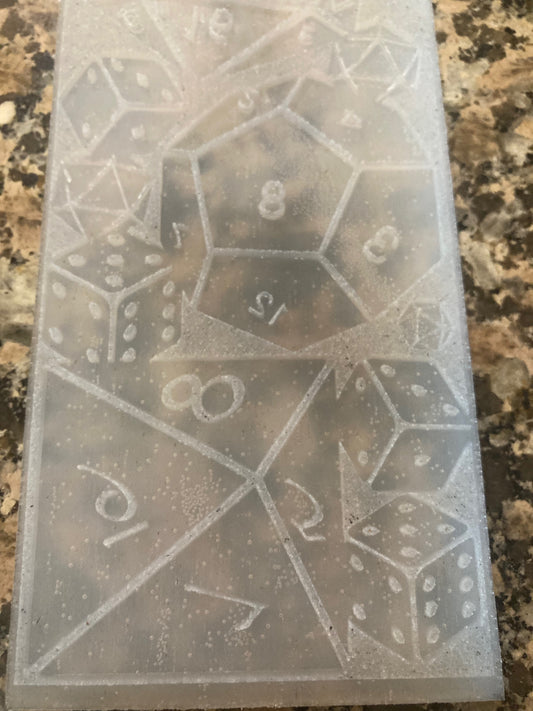 Transparent silicone mold with dice patterns on a marble surface