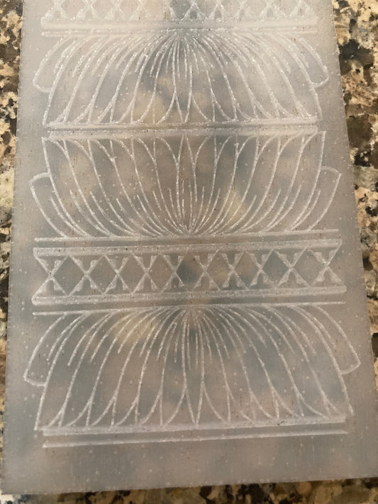 Decorative silicone mat with intricate cut-out patterns on a textured surface