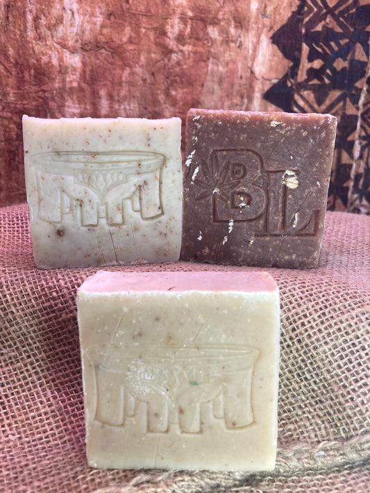 Three bars of soap with embossed letters on a textured surface