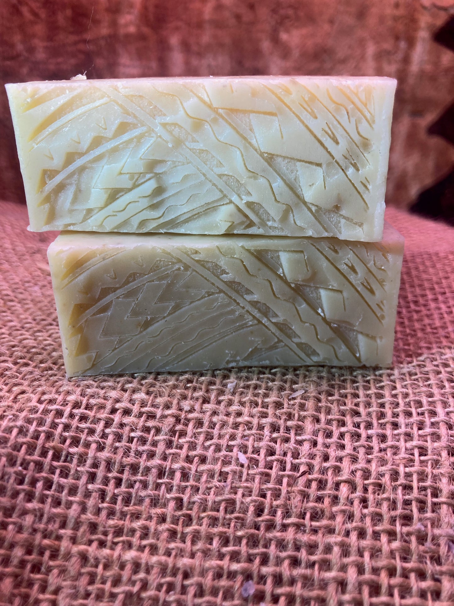 Two bars of soap with a textured surface on a burlap background