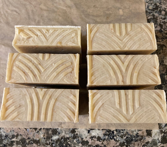 Six rectangular soap bars with decorative patterns on a marble surface
