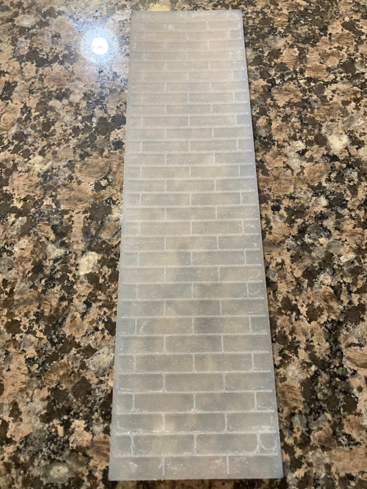 Rectangular silicone mat with a staggered brick pattern, on a granite surface