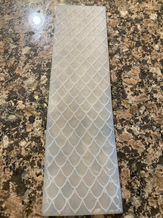 Decorative silicone mat with fish scale pattern on a granite surface