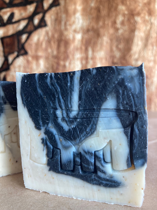 Bar of soap with black and white marbled pattern on a brown background
